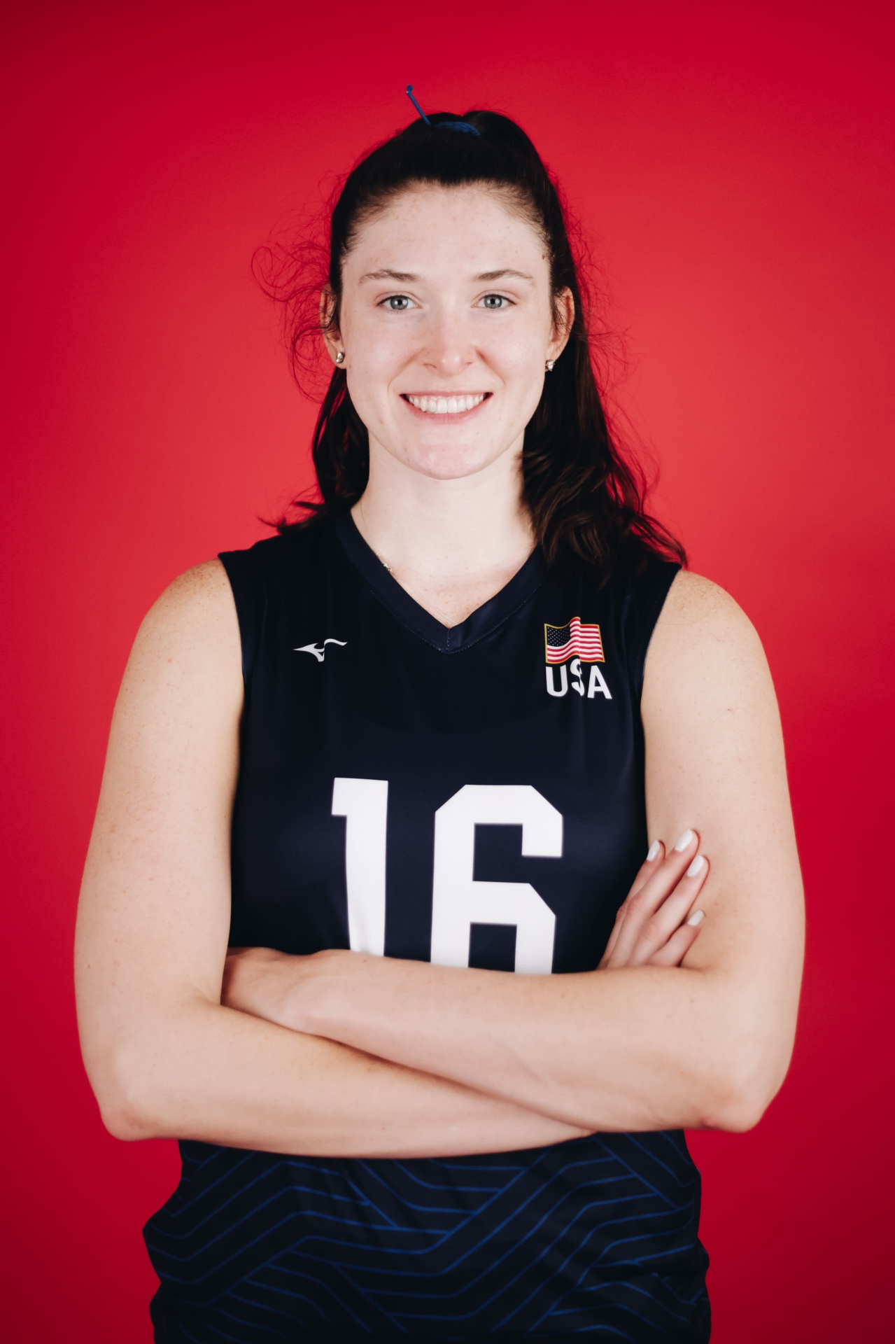 Dana Rettke headshot in Team USA jersey number 16 on a red backdrop.