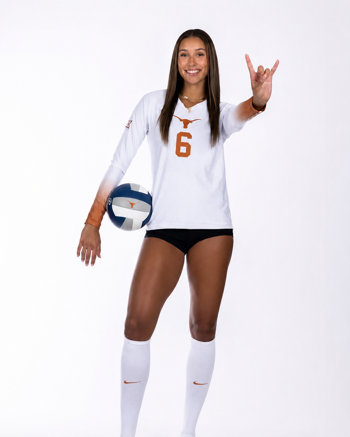 Madisen Skinner in her University of Texas #6 jersey holding a volleyball and flashing the Hook 'em Horns sign.